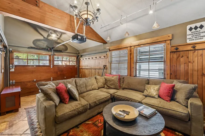 Vaulted ceiling with exposed wood beam and chandelier lighting