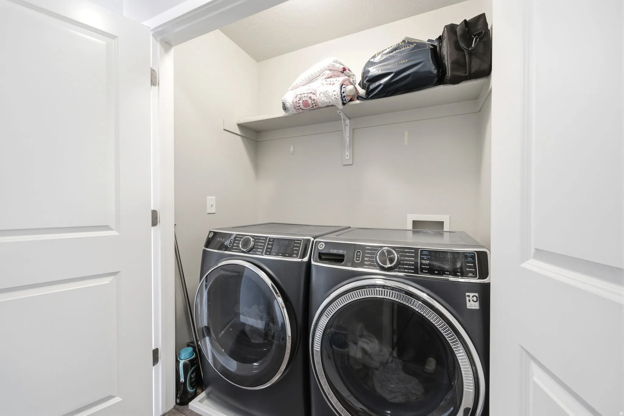 Dedicated laundry area featuring a built-in shelf and light gray walls