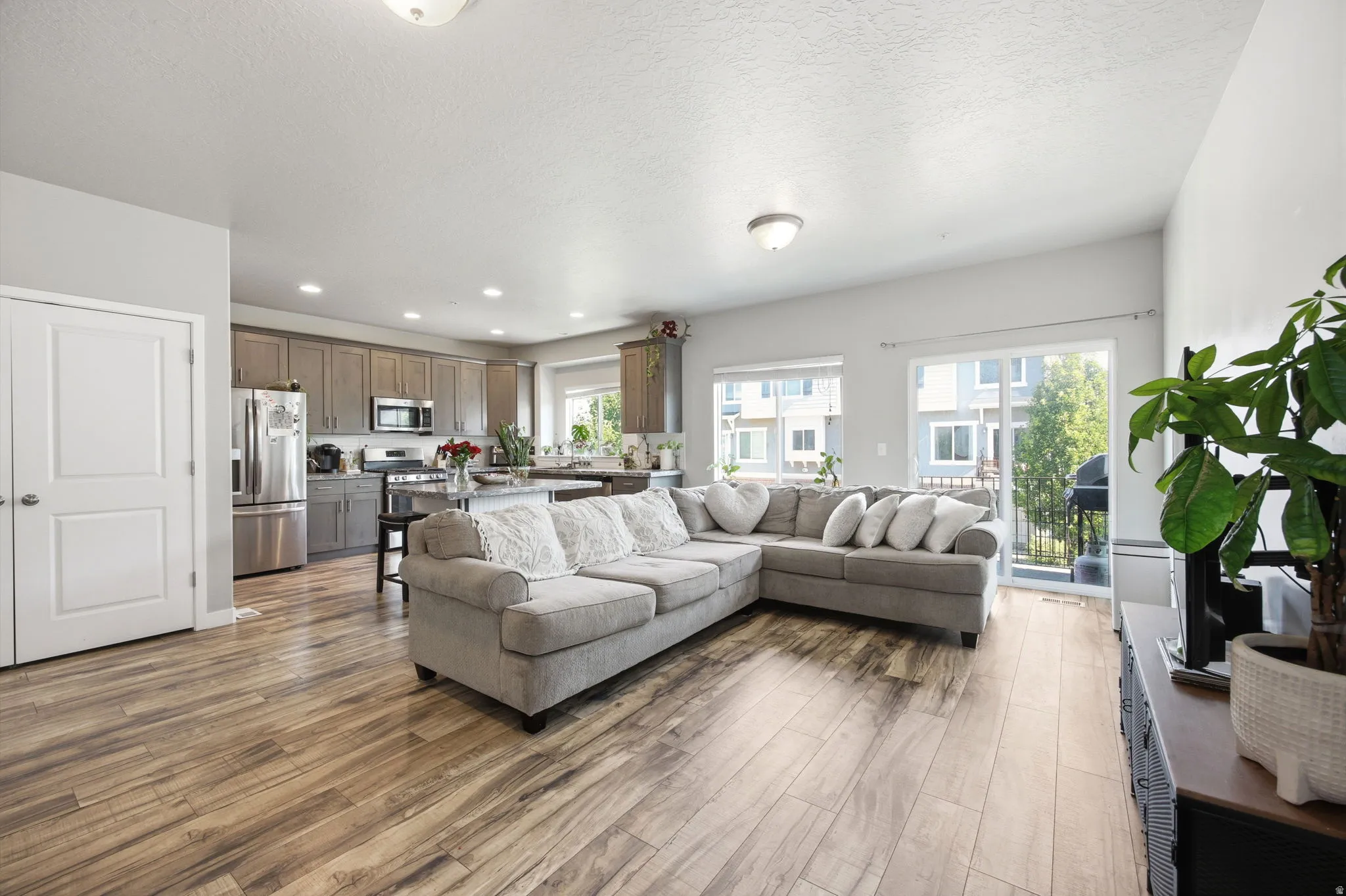 Open-concept living space featuring wood-finish flooring,  and a sliding glass door leading to an outdoor area