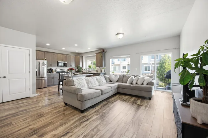 Open-concept living space featuring wood-finish flooring,  and a sliding glass door leading to an outdoor area