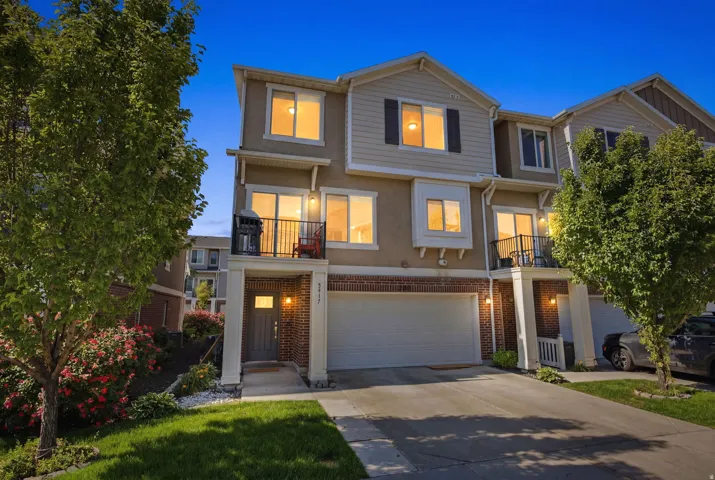 Multi-story townhome featuring a stucco and brick exterior with contrasting siding