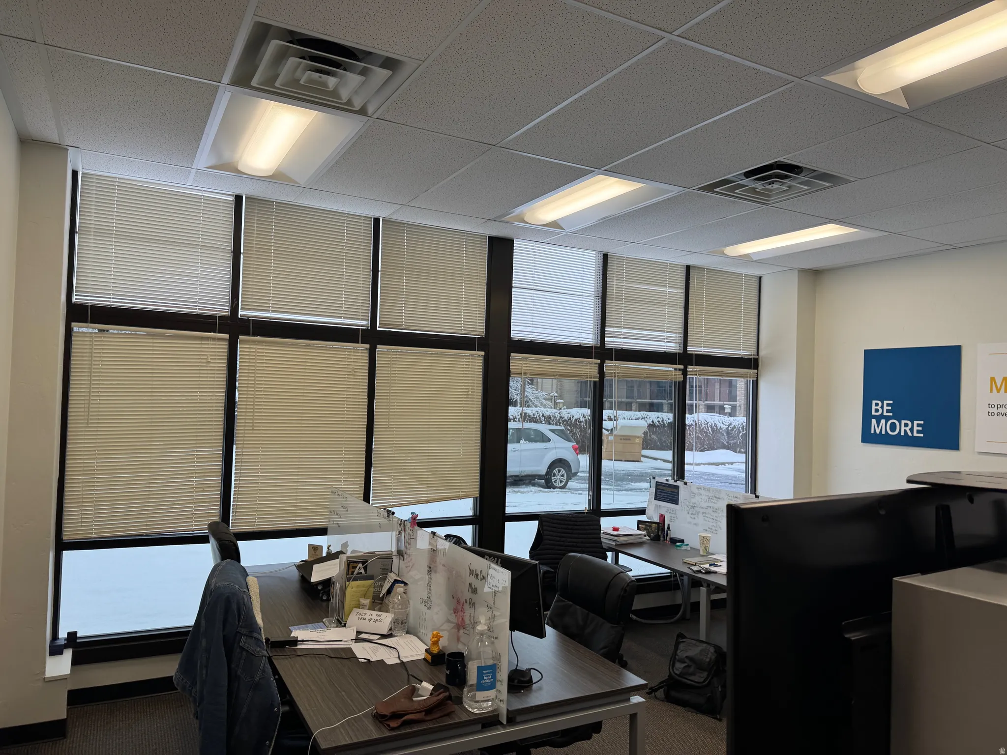 Office interior featuring a grid ceiling with recessed LED lighting and central air vents