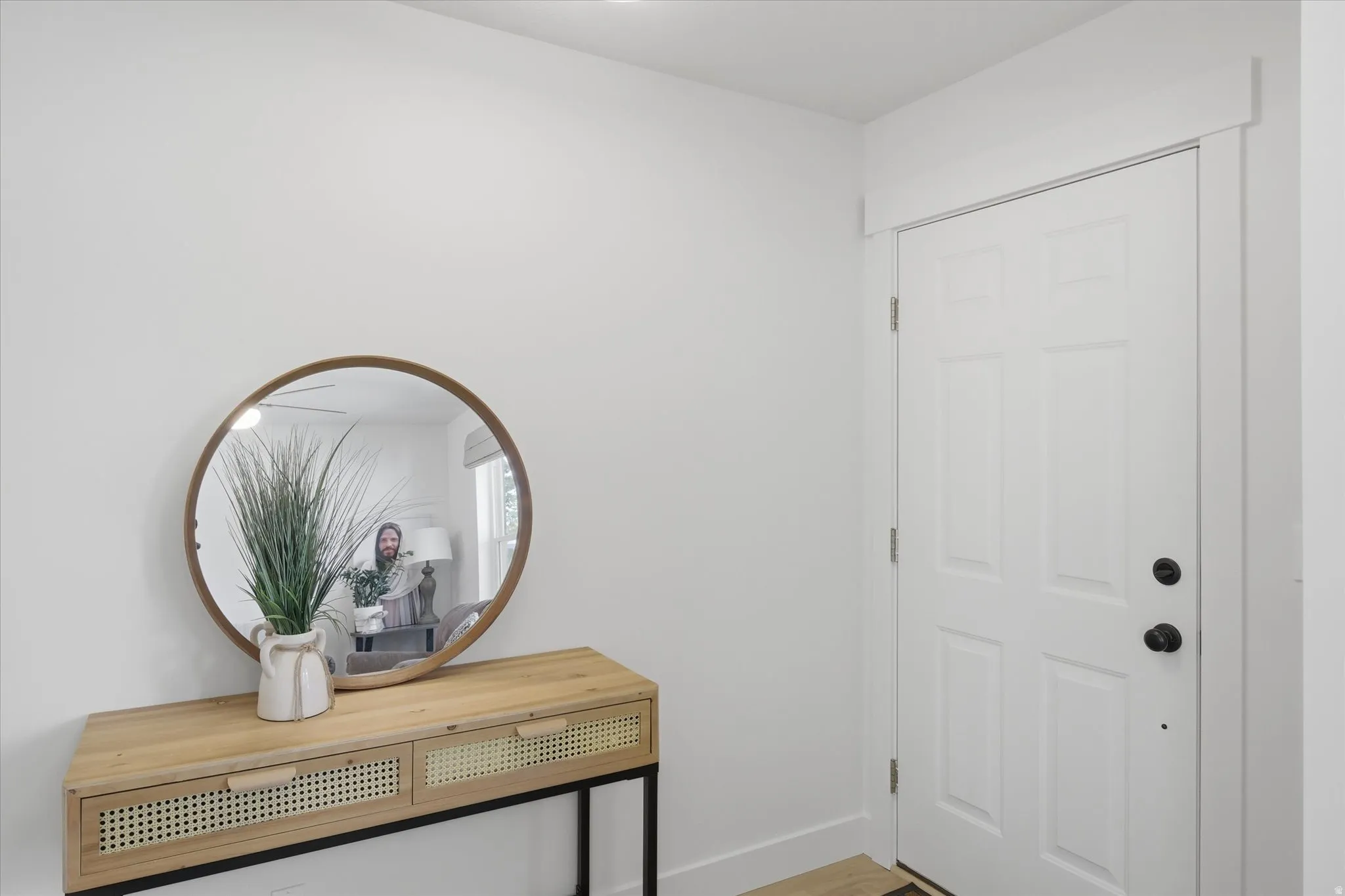 Entryway featuring a white paneled door with matte black hardware, white baseboards, and a neutral wall color