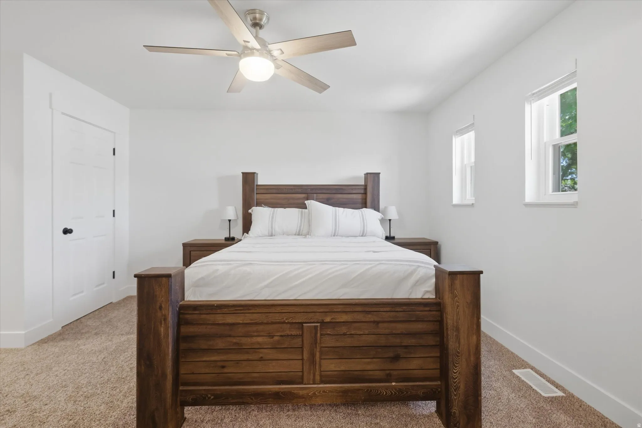 Room featuring light-colored carpeting, white walls, and a contemporary ceiling fan with integrated lighting