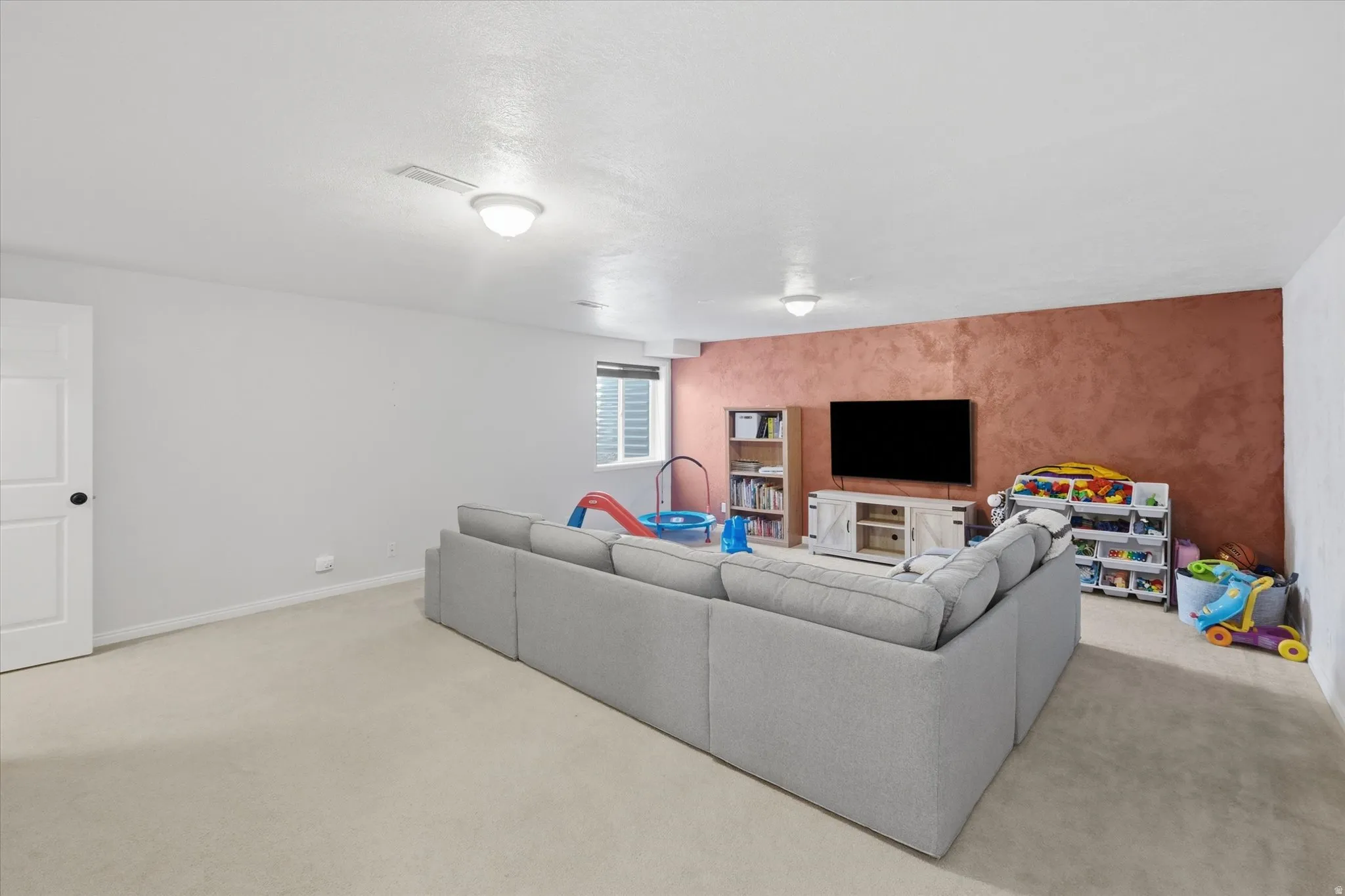 Lower-level room with light-toned carpeting and neutral wall finishes