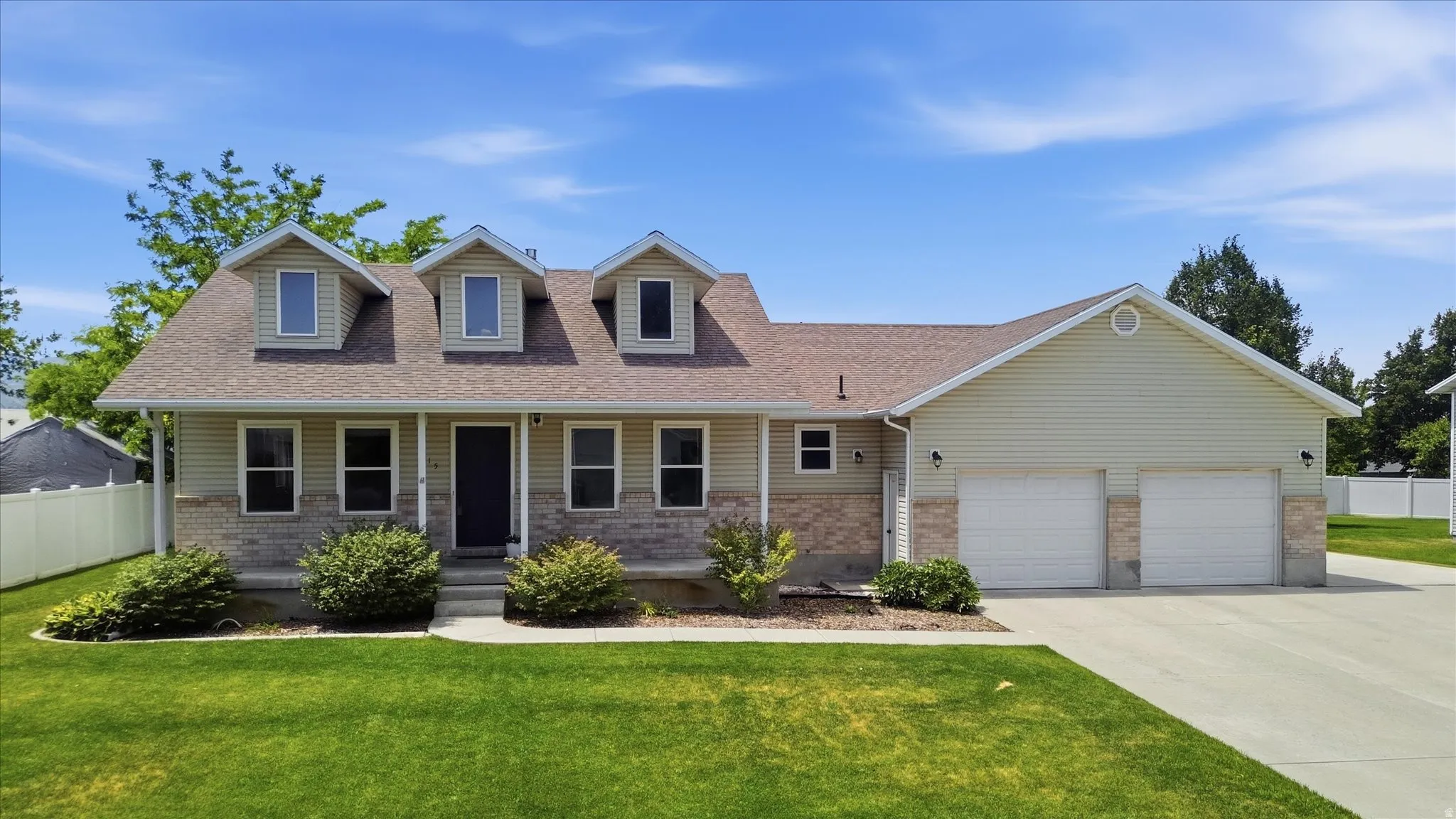 Two-story residence featuring light-colored siding, a stone facade, and a brown shingle roof
