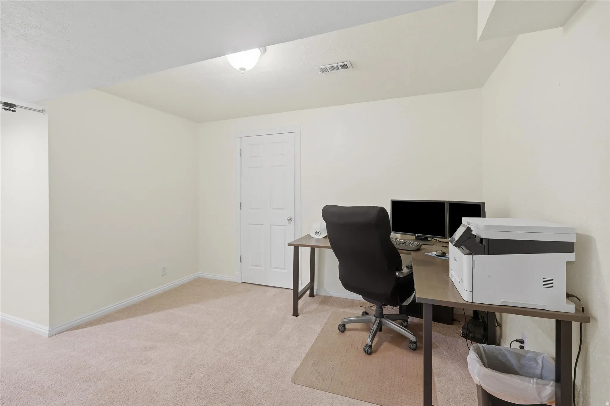 Carpeted room with light-toned walls and a white paneled door