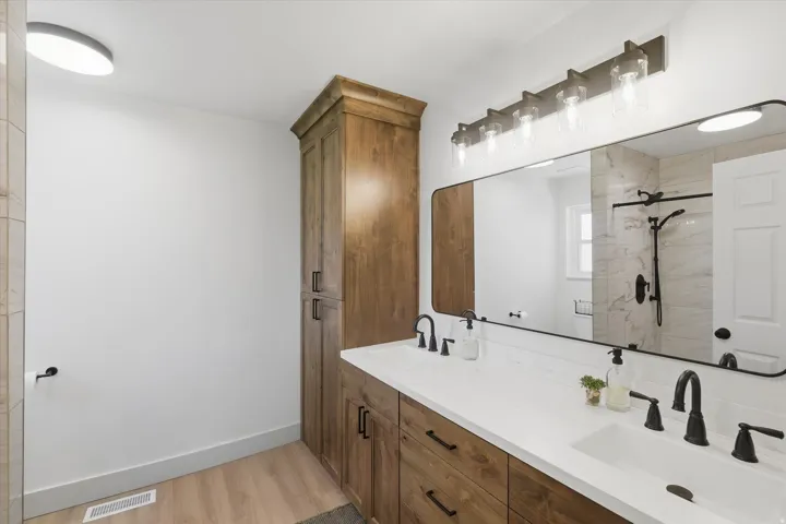 Dual vanity featuring undermount sinks, white countertops, and matte black fixtures