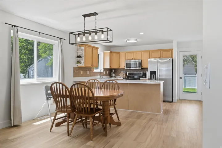 Open-concept kitchen and dining area featuring light wood-finish flooring