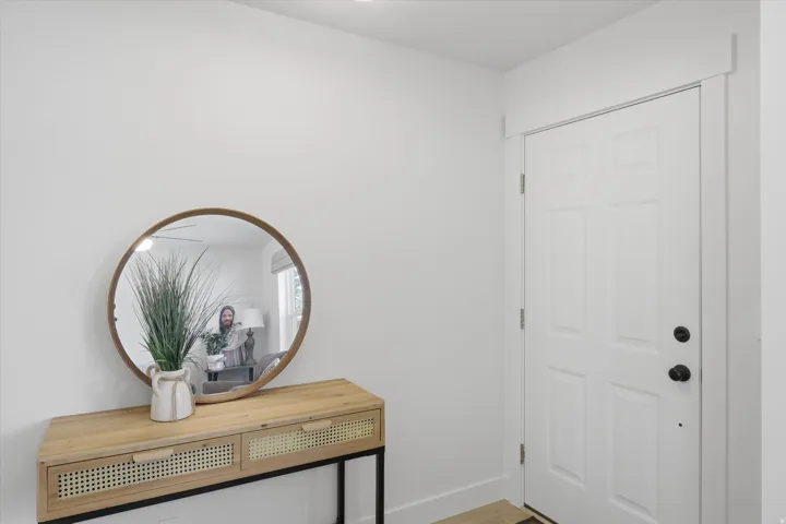 Entryway featuring a white paneled door with matte black hardware, white baseboards, and a neutral wall color