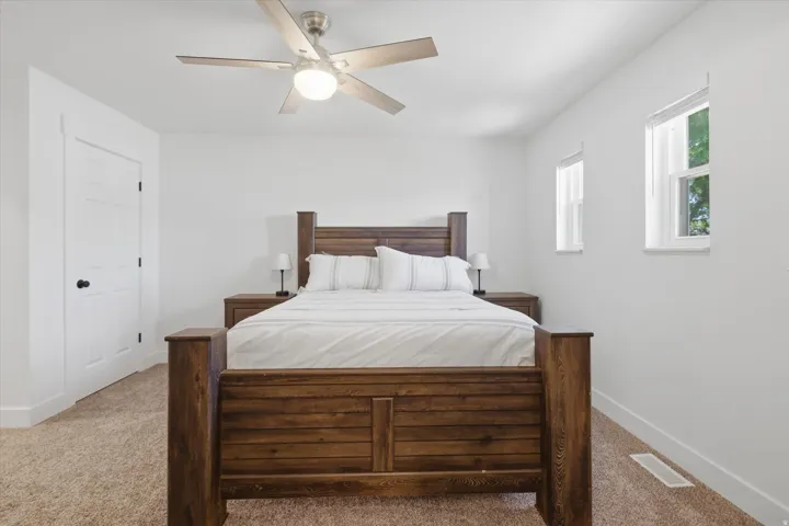 Room featuring light-colored carpeting, white walls, and a contemporary ceiling fan with integrated lighting