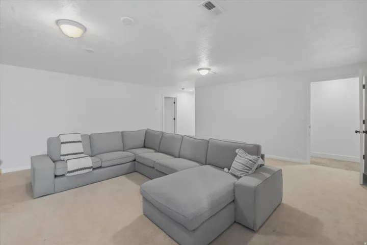 Carpeted room with white walls, two flush-mount ceiling lights, and an open doorway