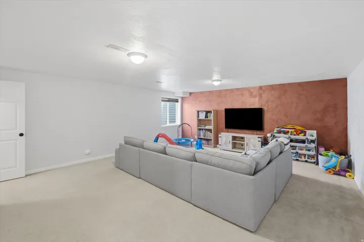 Lower-level room with light-toned carpeting and neutral wall finishes