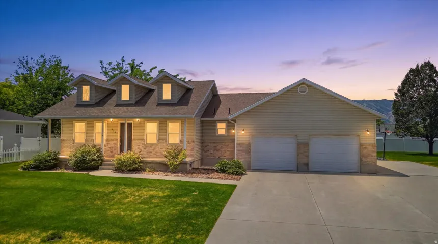 Ranch-style residence featuring a combination of siding and stone veneer, a covered front porch, and three dormer windows