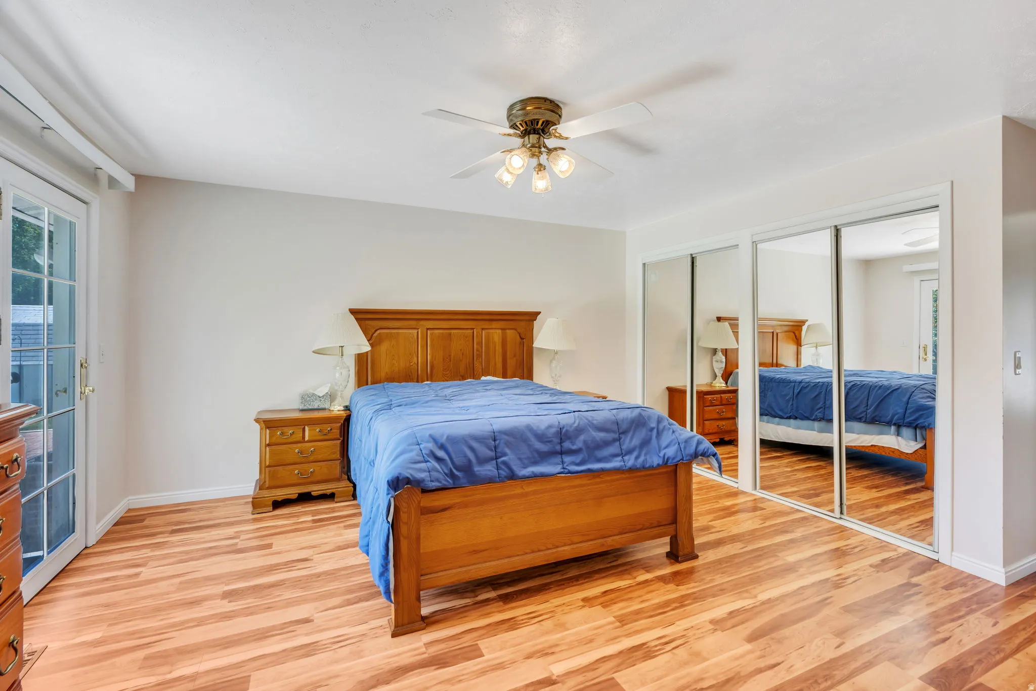Room featuring wood-finish flooring and a ceiling fan with integrated lighting
