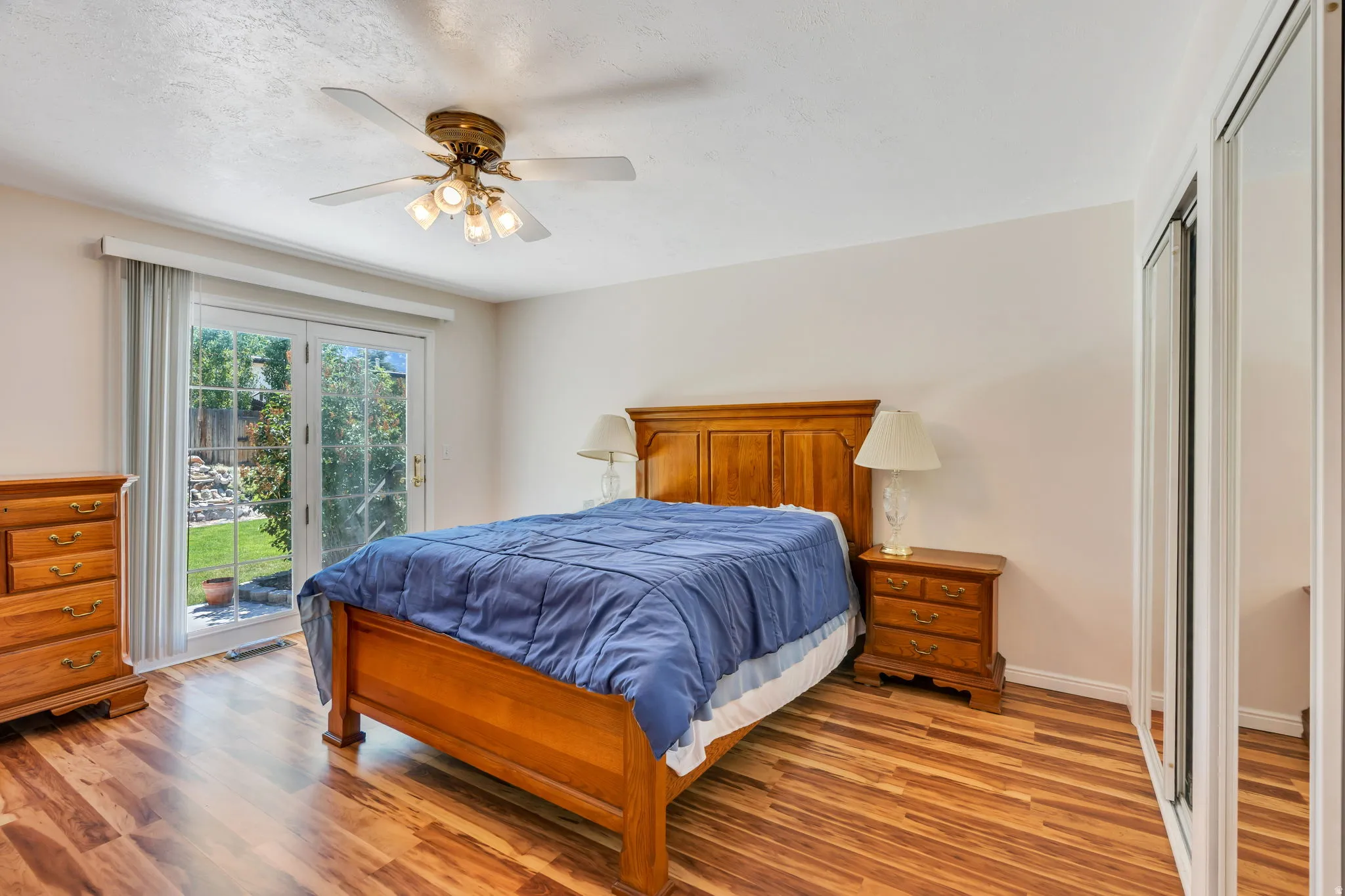 Wood-finish flooring throughout, featuring a ceiling fan with integrated lighting