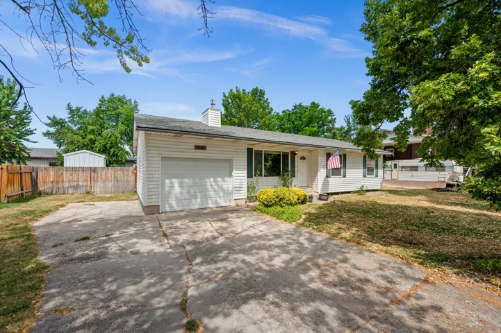 Ranch-style residence featuring white horizontal siding, an attached garage, and a concrete driveway
