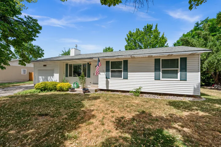White horizontal siding exterior with dark green window shutters, a front entry with porch, and an attached single-car garage