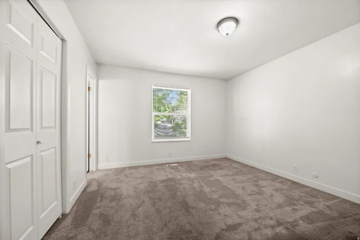 Neutral-toned wall paint and carpet flooring complement a double-pane window
