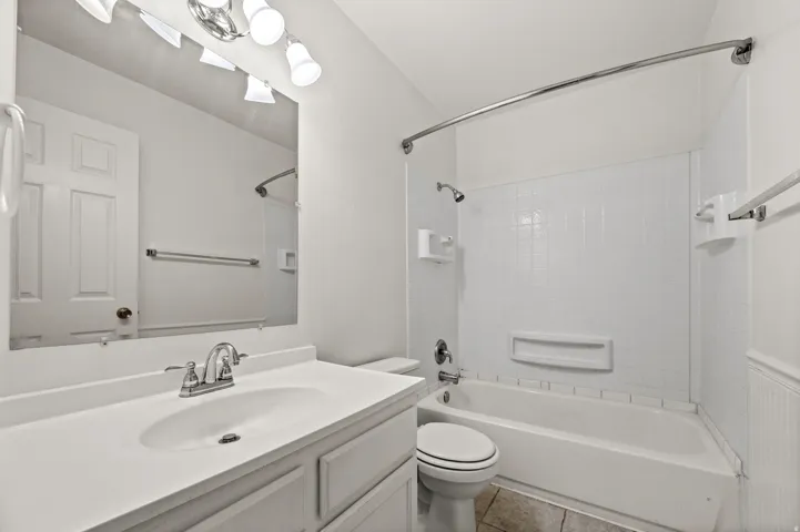 Bathroom vanity featuring a white countertop with integrated sink and chrome faucet