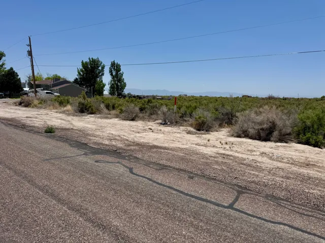Expansive undeveloped land parcel featuring natural shrubbery and distant mountain formations