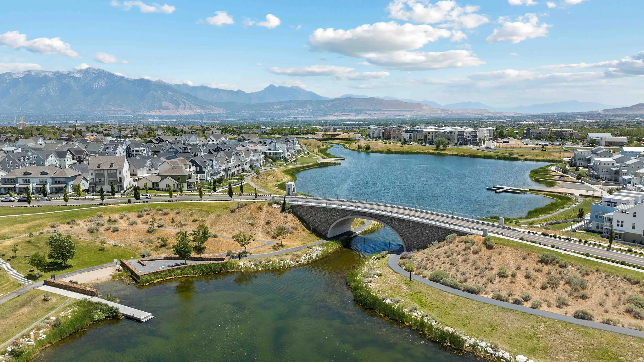 Expansive community with a large body of water, a stone arch bridge, and surrounding residential properties