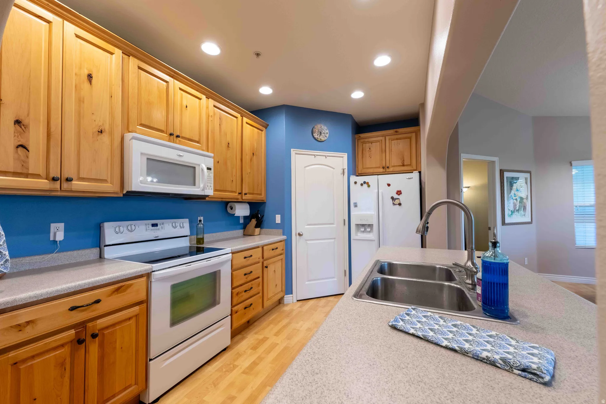 Kitchen featuring wood cabinetry, light-toned countertops, and wood-finish flooring