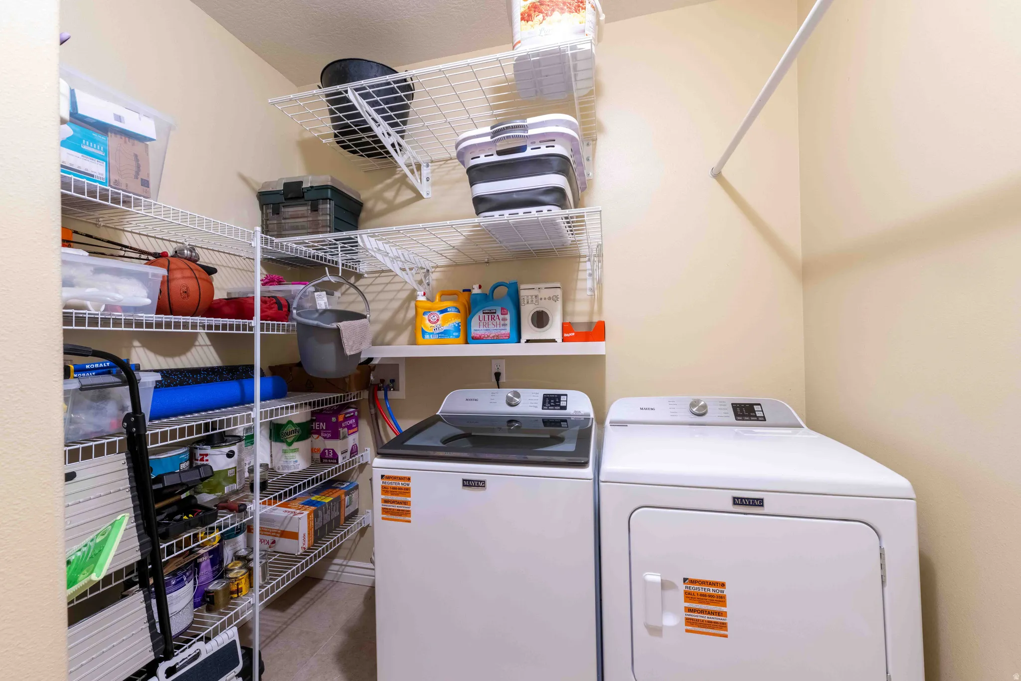 Dedicated utility space that includes a washing machine and dryer the was purchased 1 year ago, along with extensive wire shelving for organization