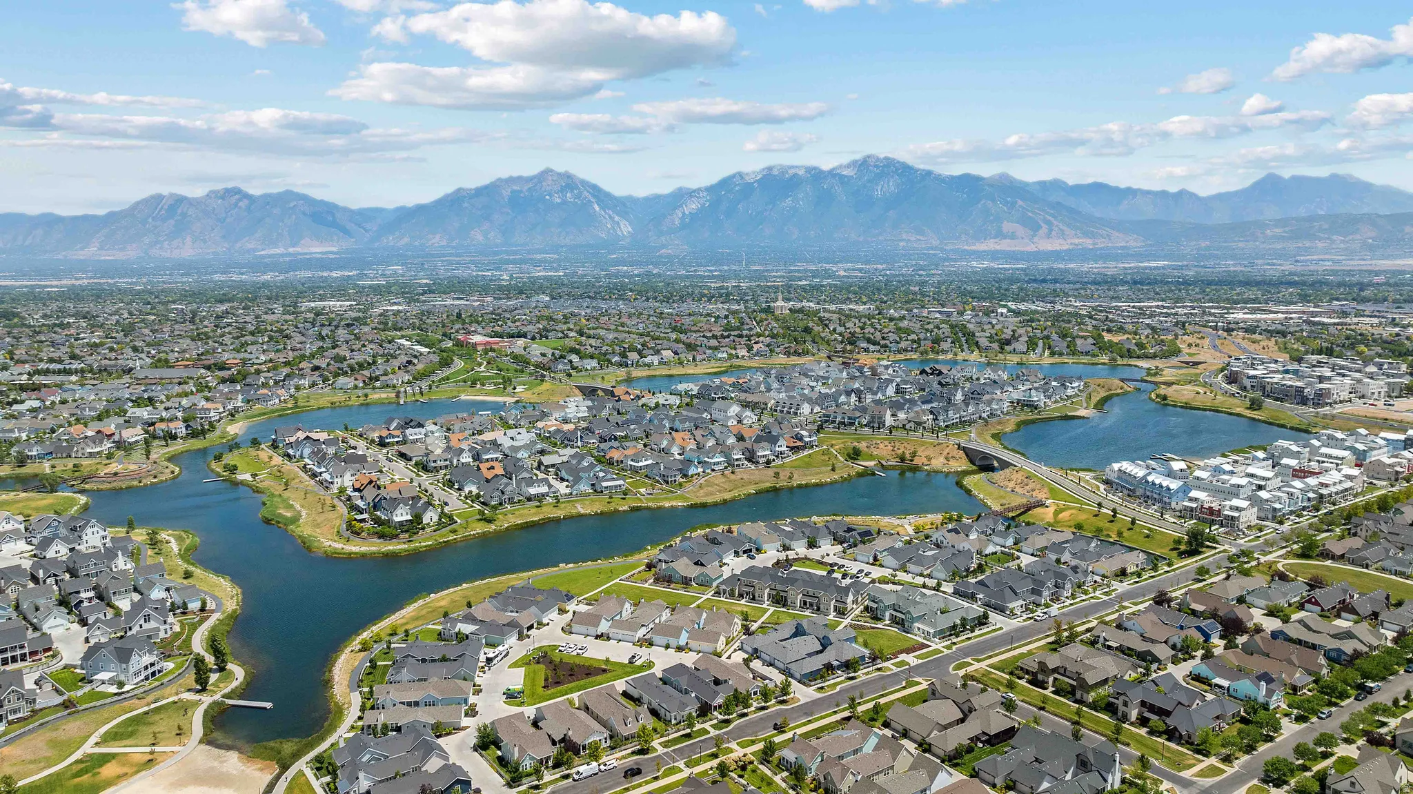 Expansive aerial perspective showcasing a residential community with a large central lake and surrounding green spaces