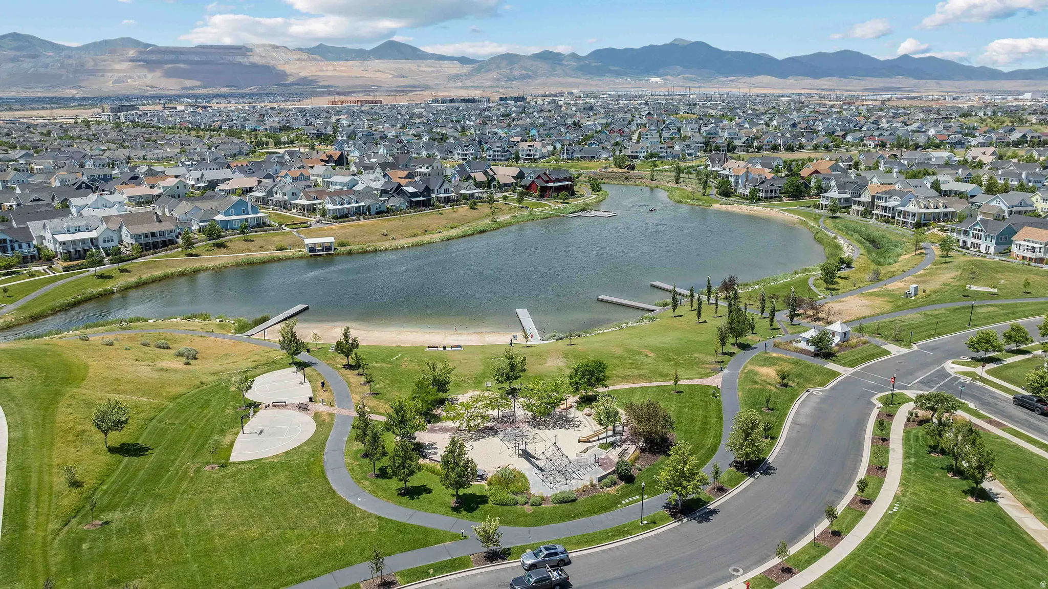 Expansive community featuring a central lake with docks and a sandy beach area