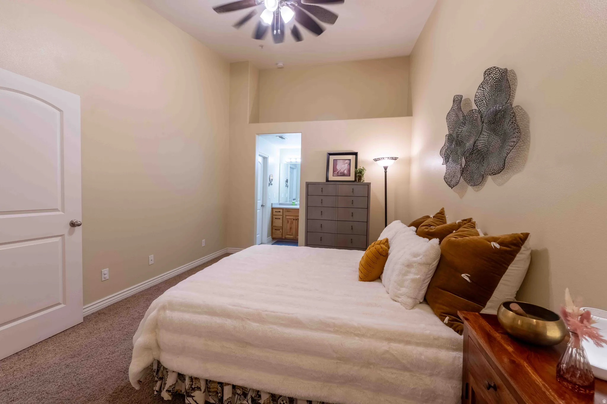 Carpeted bedroom featuring a vaulted ceiling and a ceiling fan