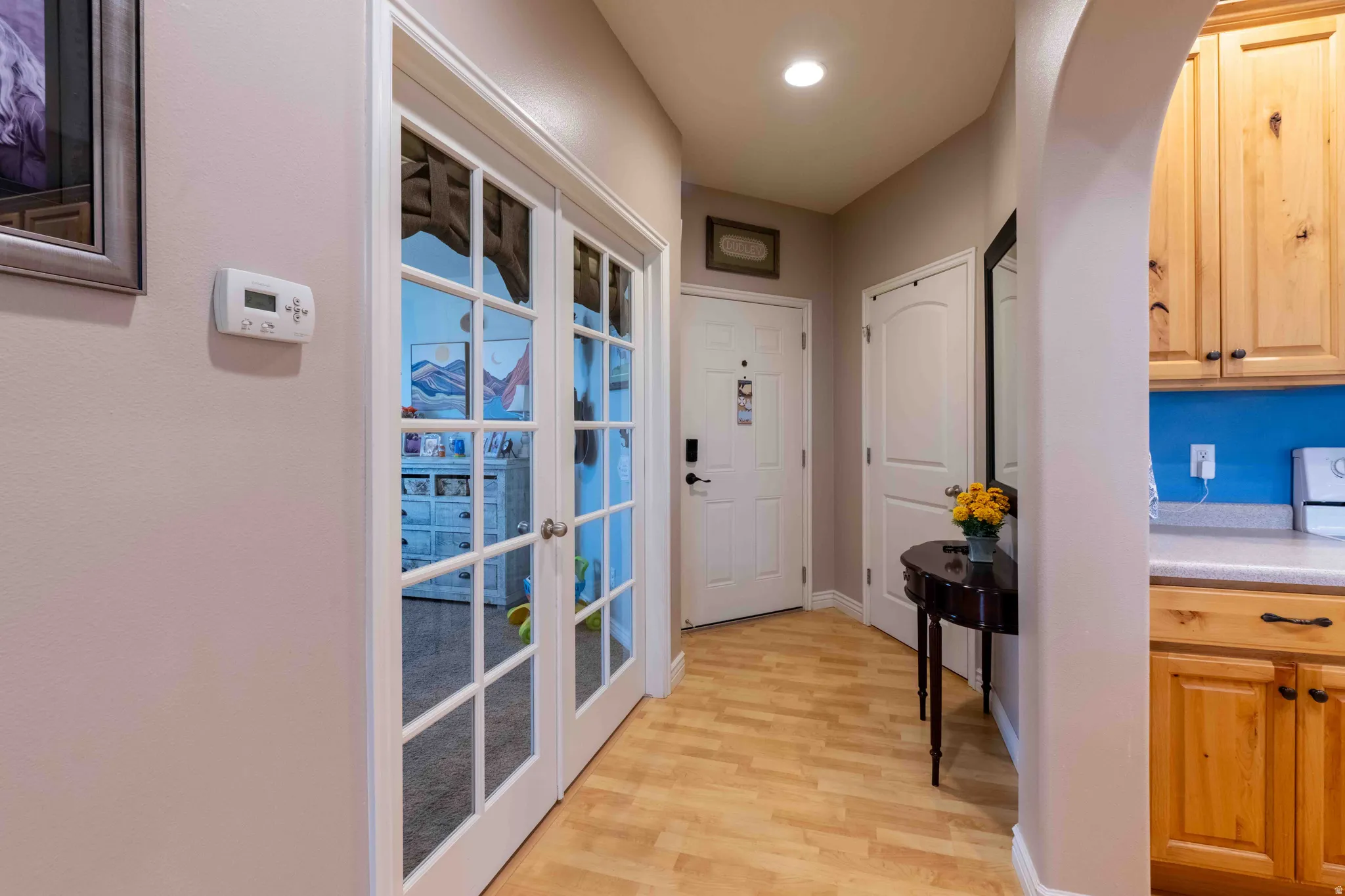 Entryway featuring light wood-finish flooring, a white front door with dark hardware, and recessed ceiling lighting