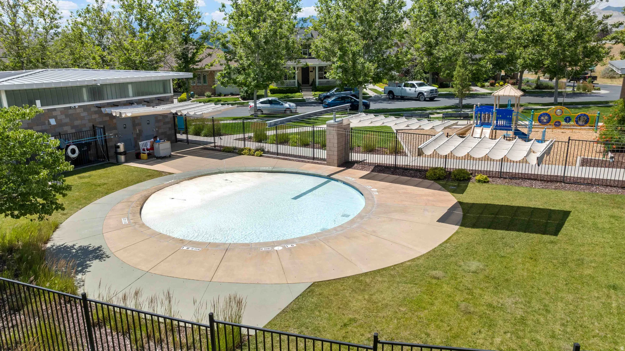 Community splash pad area with adjacent playground with slides