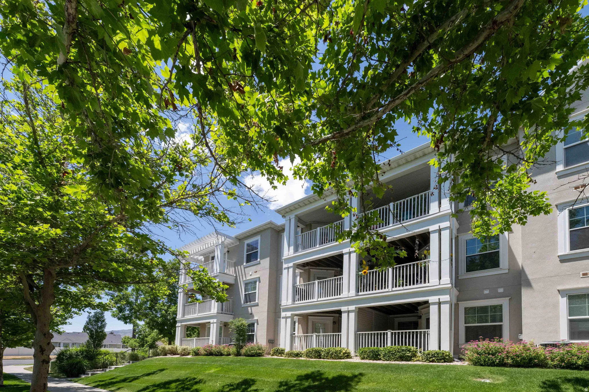 Multi-story residential condo building with stucco exterior and white trim