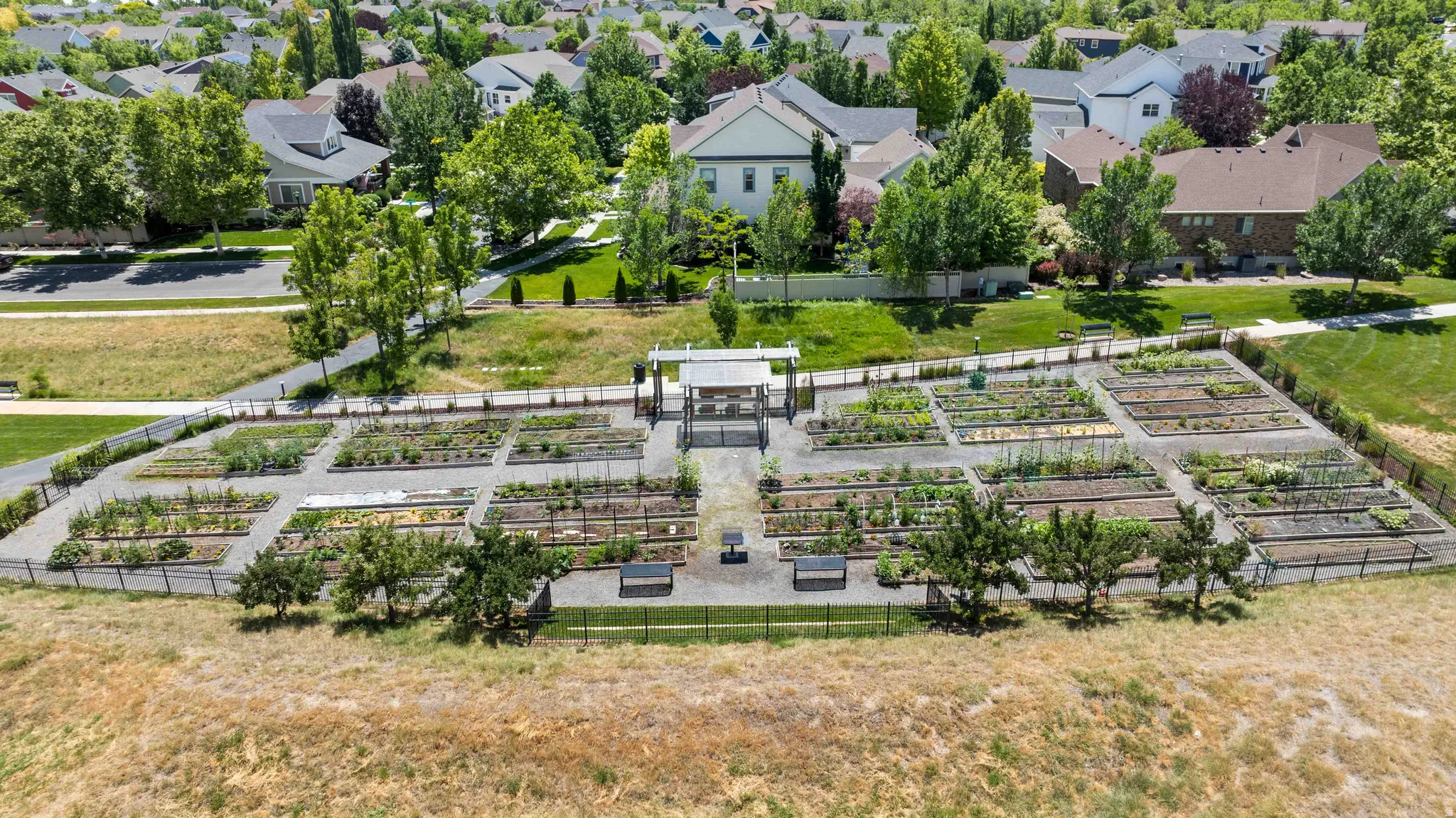One of Daybreaks many community garden plots featuring established planting beds, gravel pathways, and perimeter fencing