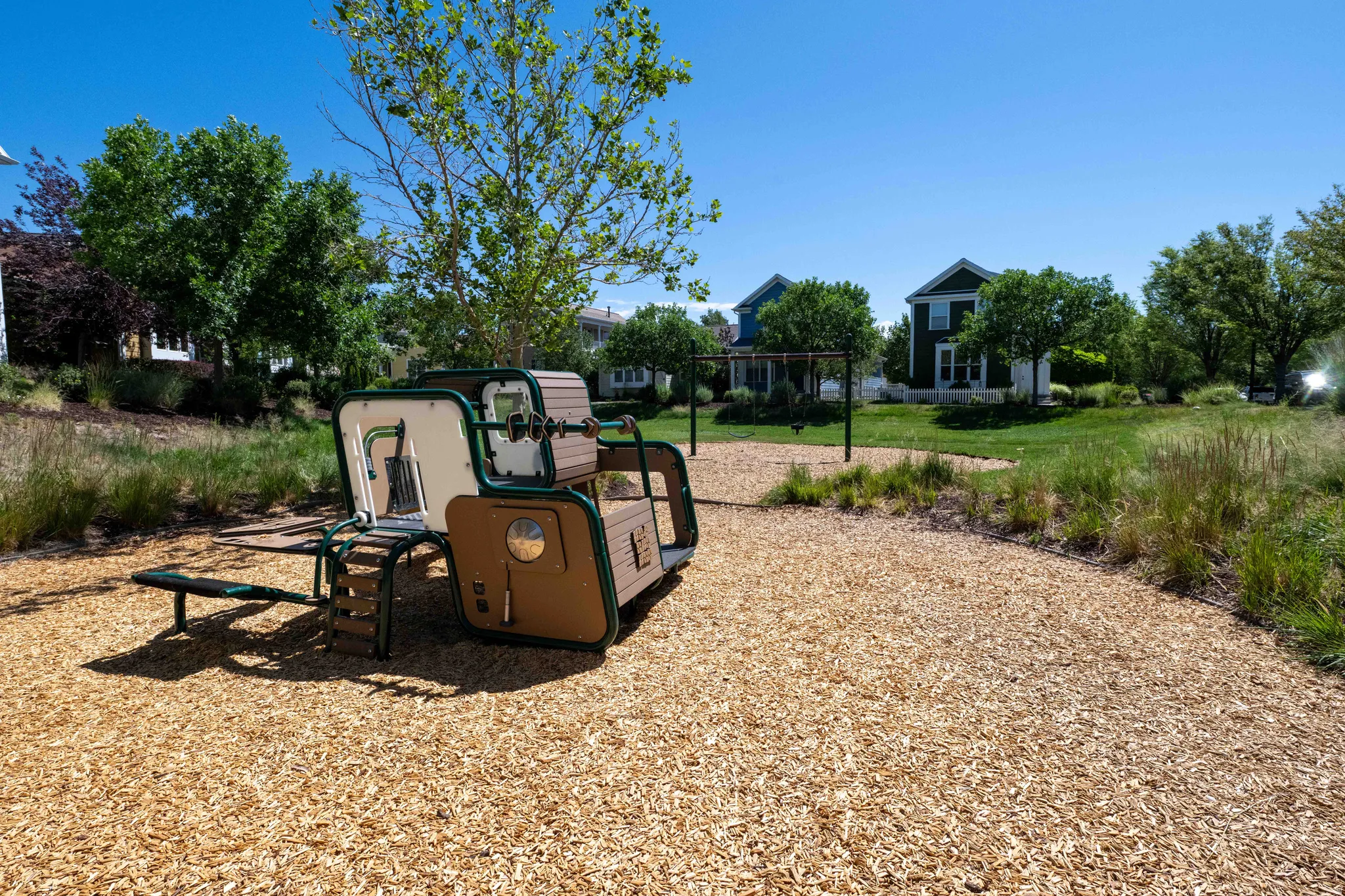 Peak-a-boo park outdoor recreational area featuring a modern play structure with multiple activity zones, set on a wood chip surface