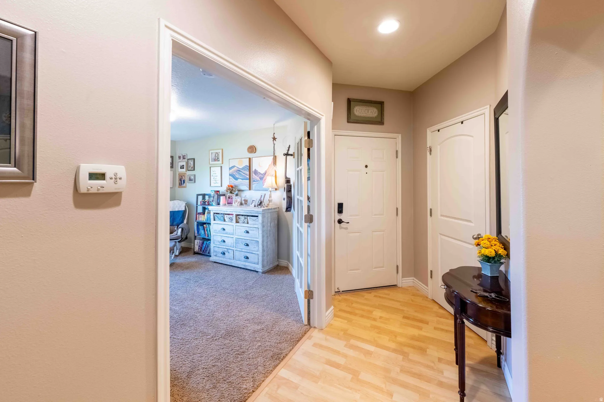 Entryway featuring wood-finish flooring, a white paneled door with contemporary hardware, and recessed ceiling lighting
