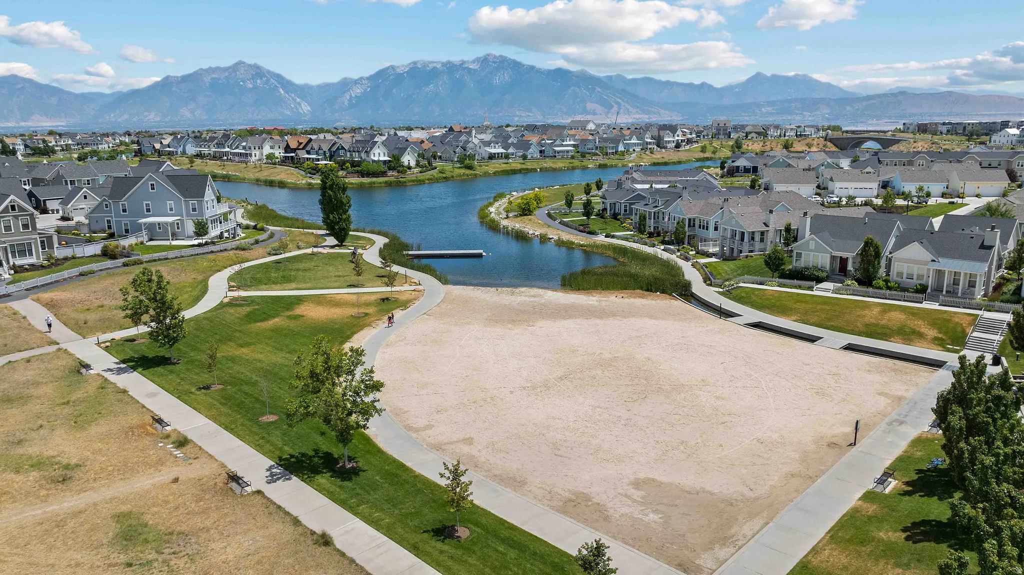 Expansive sand area bordered by concrete pathways and green space