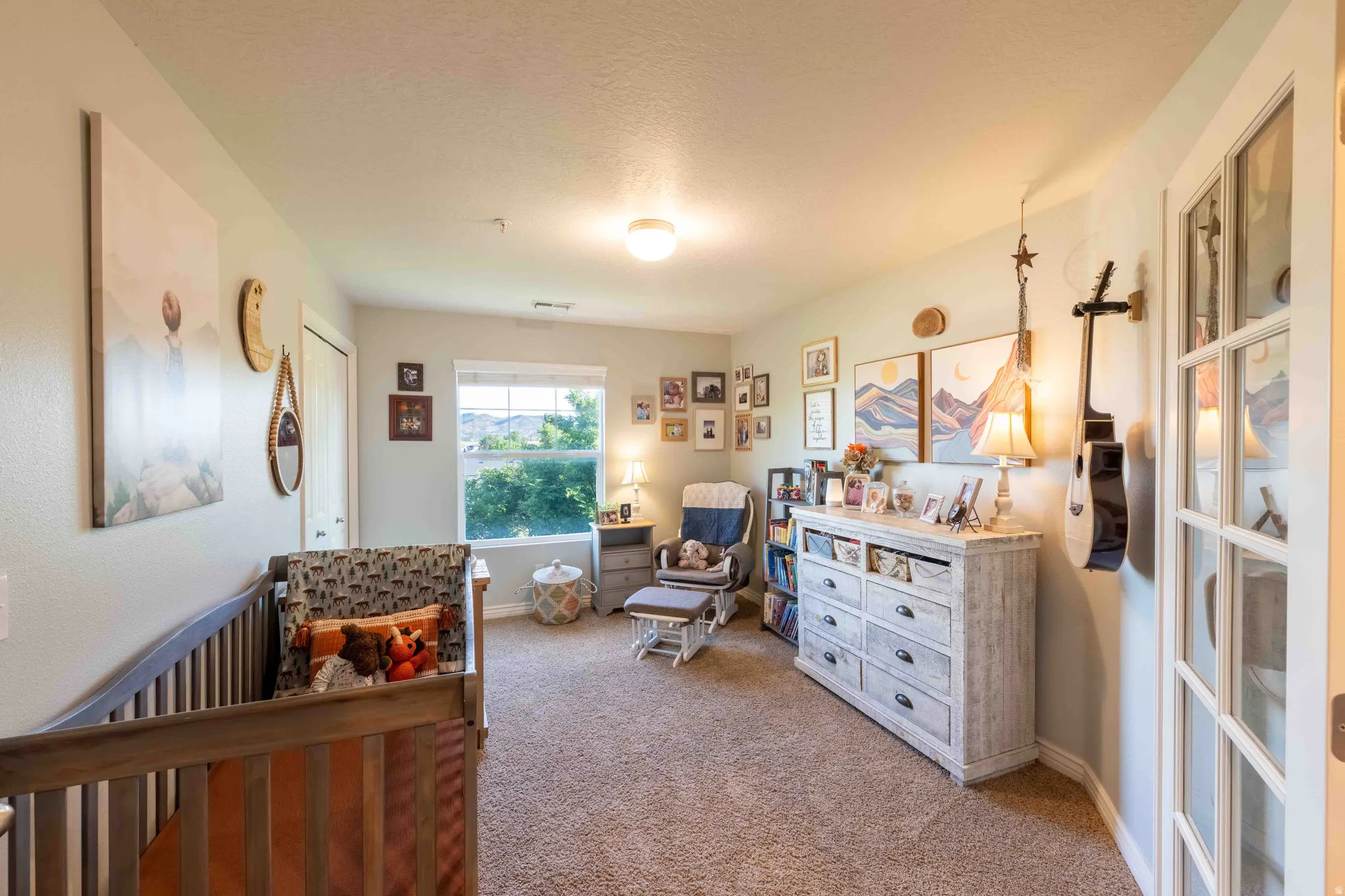 Carpeted room featuring a window with exterior visibility, a ceiling light fixture, and a white paneled door