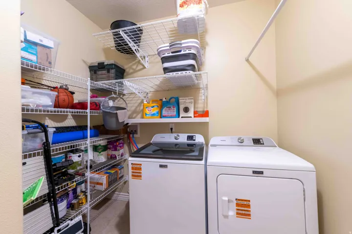 Dedicated utility space that includes a washing machine and dryer the was purchased 1 year ago, along with extensive wire shelving for organization