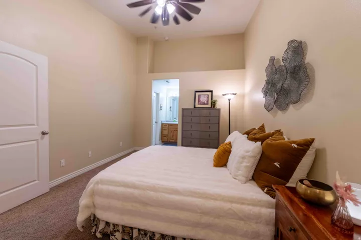 Carpeted bedroom featuring a vaulted ceiling and a ceiling fan