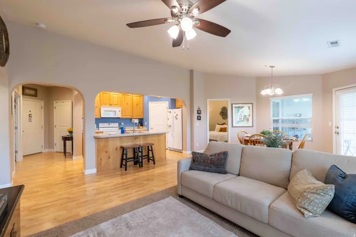Open-concept living area featuring a vaulted ceiling and wood-finish flooring