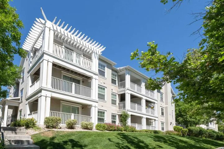 Multi-story building featuring stacked balconies with white railings and columns