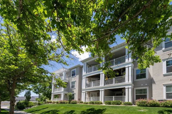 Multi-story residential condo building with stucco exterior and white trim