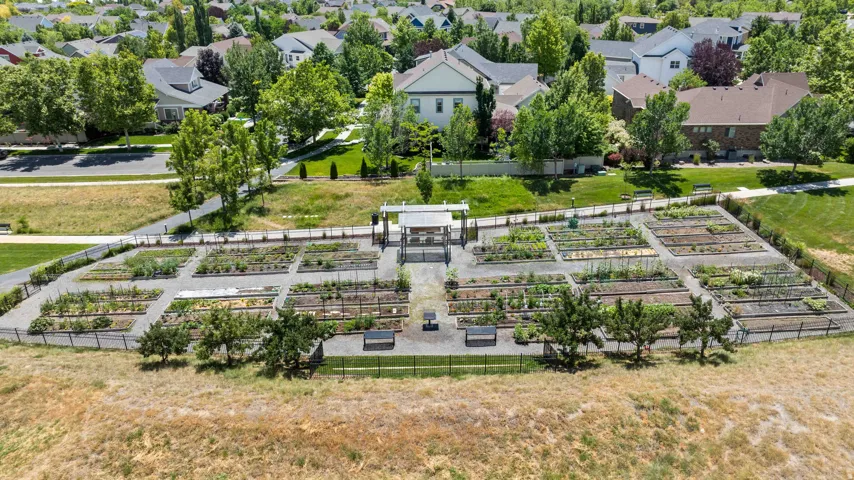 One of Daybreaks many community garden plots featuring established planting beds, gravel pathways, and perimeter fencing