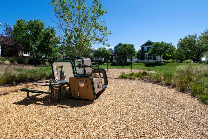 Peak-a-boo park outdoor recreational area featuring a modern play structure with multiple activity zones, set on a wood chip surface