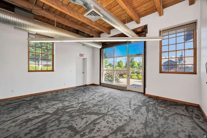 Expansive interior space featuring exposed wood beam ceilings and visible ductwork