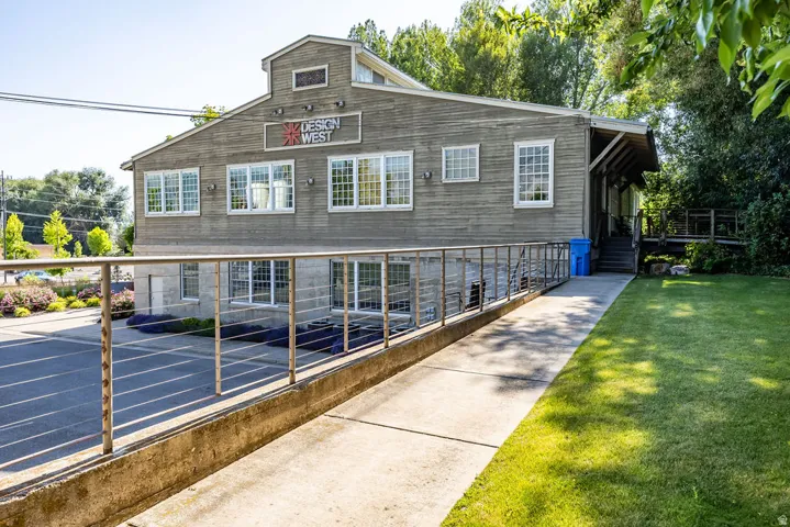 Two-story commercial building with horizontal siding and multiple double-hung windows