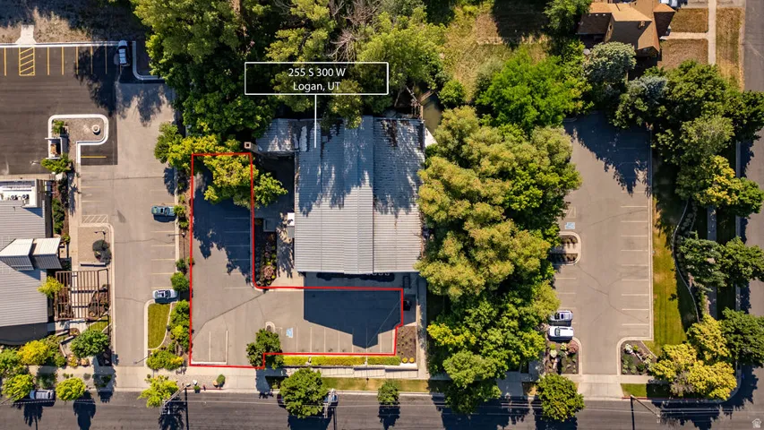 Aerial perspective showcasing a commercial building with a grey roof and a dedicated paved parking area