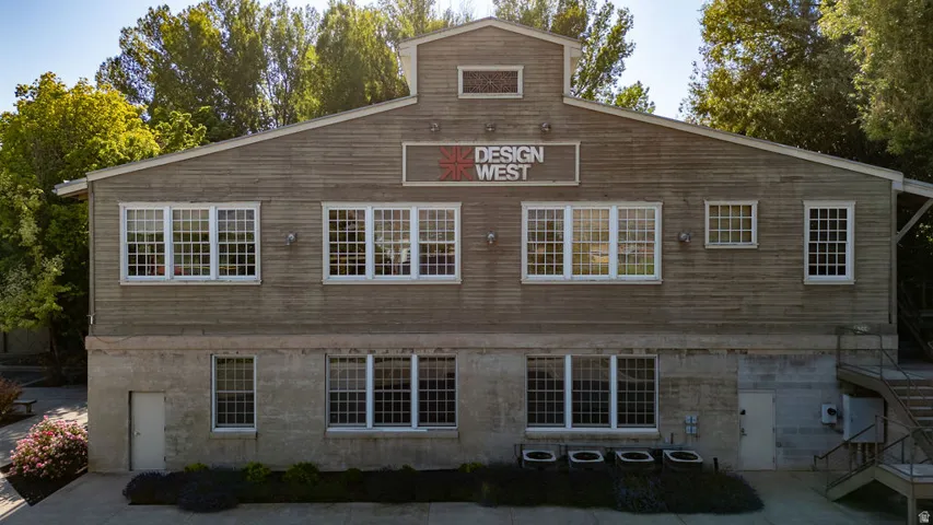 Two-story commercial building featuring extensive grid-pattern windows, a wood-sided upper level, and a concrete-finish lower level